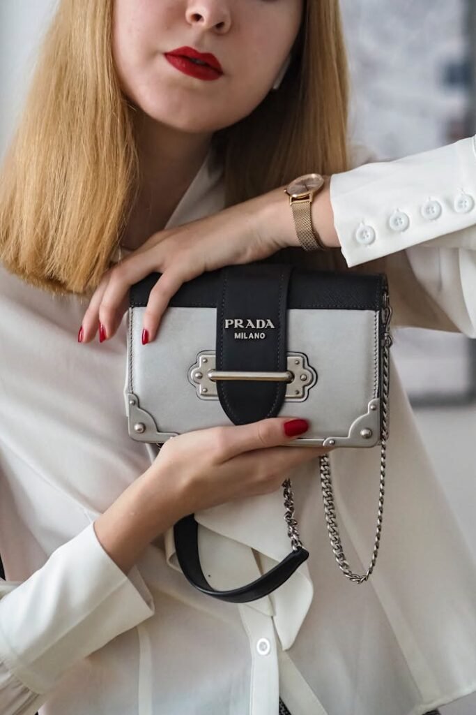 Stylish woman showcasing a luxury Prada handbag with a chic, minimalist fashion sense.